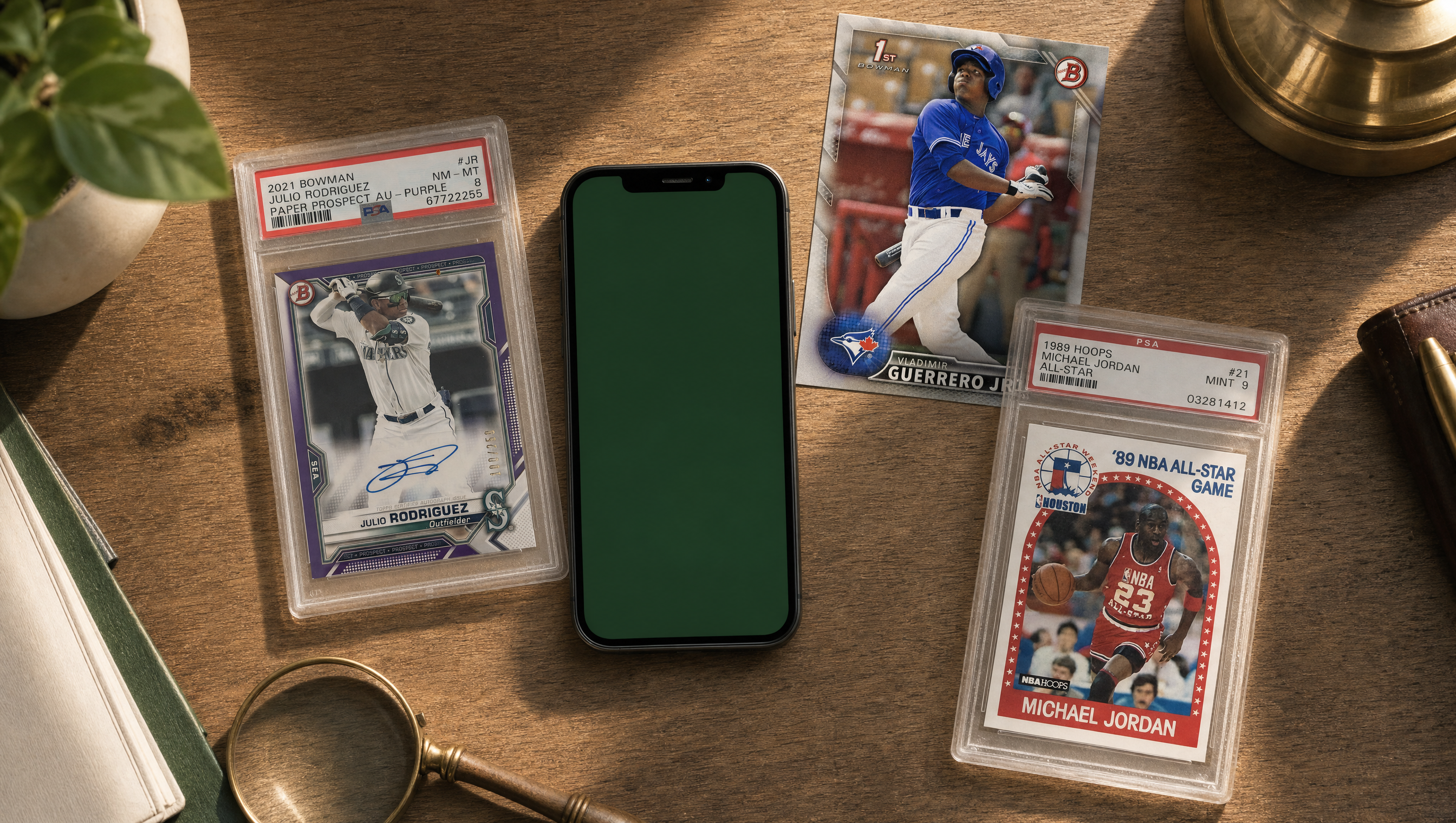 Collector's desk with three trading cards and an iPhone showing the CardBarter app